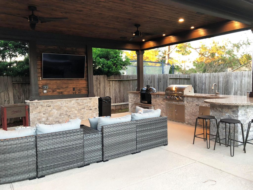 Example of a large classic backyard stamped concrete patio kitchen design in Houston with a gazebo