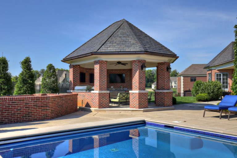 Example of a large classic backyard stone patio kitchen design in Louisville with a gazebo