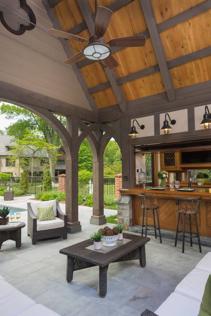 Example of a large classic backyard tile patio kitchen design in New York with a roof extension