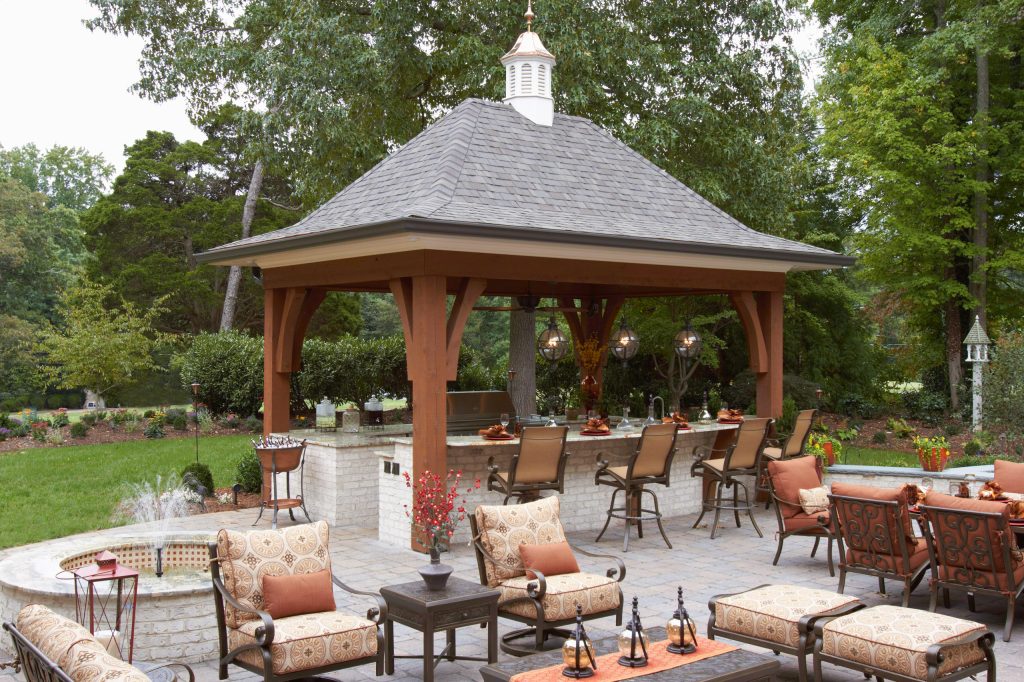 Example of a large cottage backyard concrete paver patio kitchen design in Other