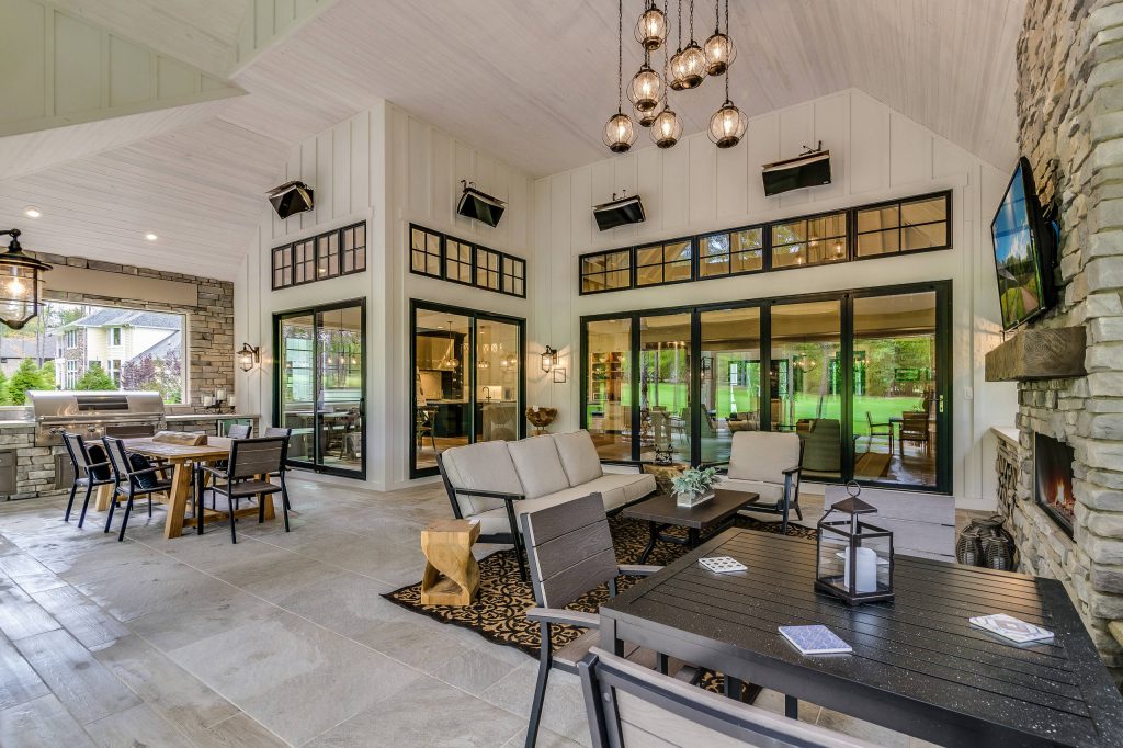 Example of a large cottage backyard stone patio kitchen design in Cleveland with a roof extension