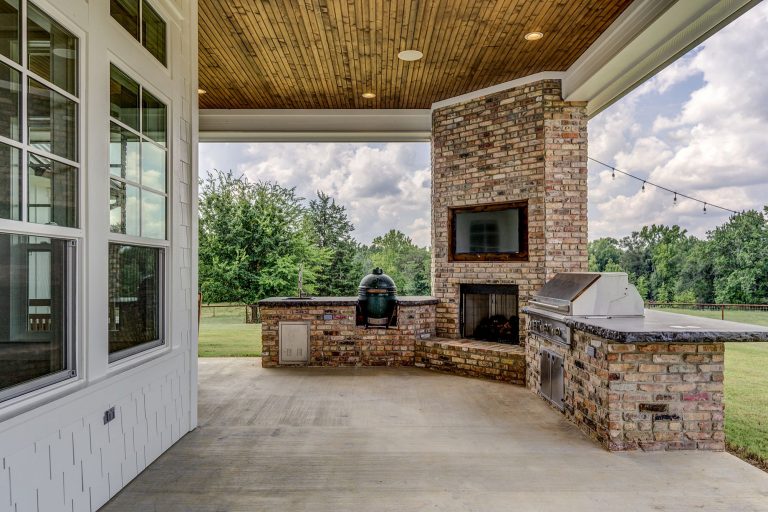 Example of a large country backyard concrete patio kitchen design in Other with a roof extension