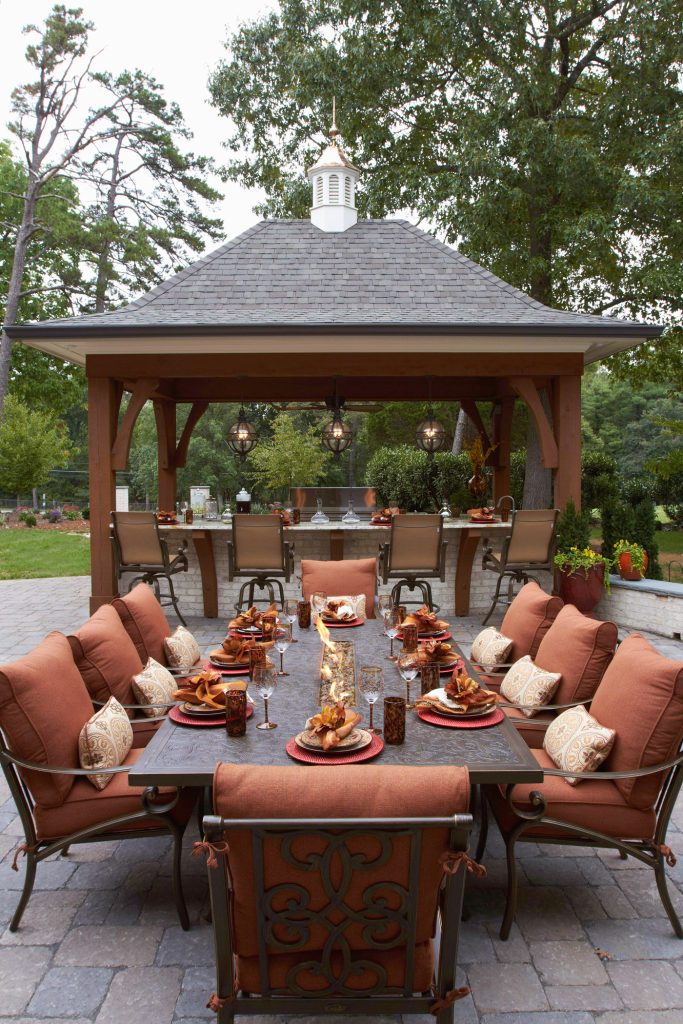 Example of a large country backyard concrete paver patio kitchen design in Other