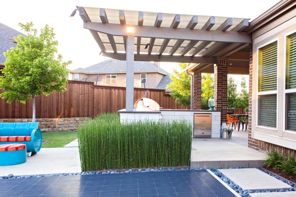 Example of a large eclectic backyard concrete paver patio kitchen design in Dallas with a pergola