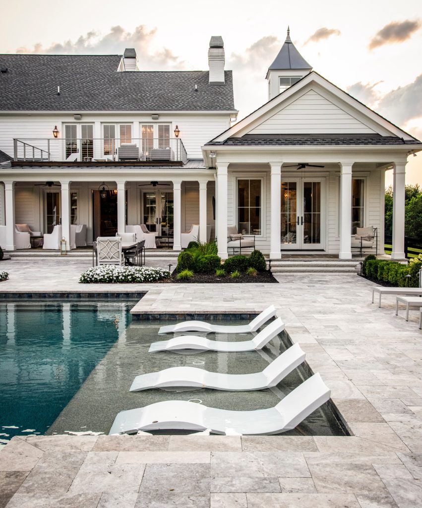 Example of a large farmhouse backyard stone and custom-shaped pool design in Nashville