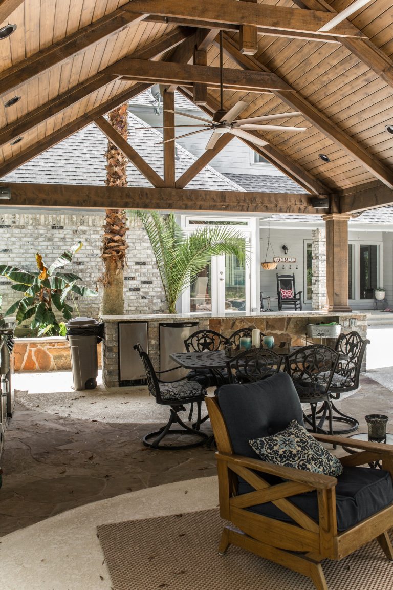 Example of a large farmhouse backyard stone patio kitchen design in Houston with a gazebo