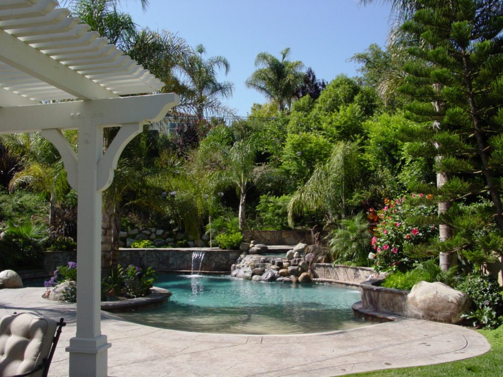 Example of a large island style backyard stone and custom-shaped natural hot tub design in Los Angeles