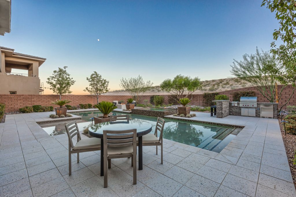 Example of a large island style backyard stone and rectangular lap hot tub design in Las Vegas