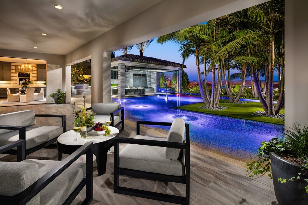 Example of a large island style backyard tile and l-shaped infinity pool house design in San Diego