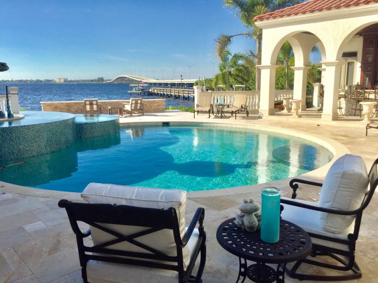 Example of a large island style backyard tile pool design in Miami