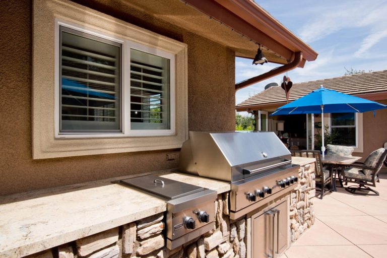 Example of a large minimalist backyard concrete patio kitchen design in Los Angeles with no cover