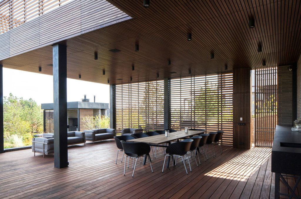 Example of a large minimalist backyard outdoor kitchen deck design in San Francisco with a roof extension