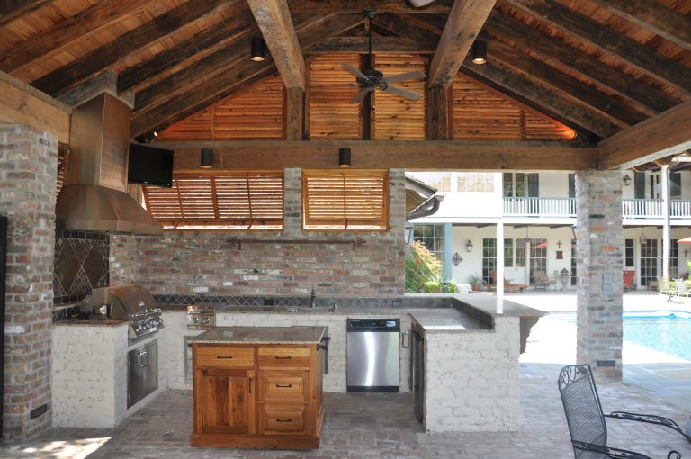 Example of a large mountain style backyard brick patio kitchen design in New Orleans with a roof extension
