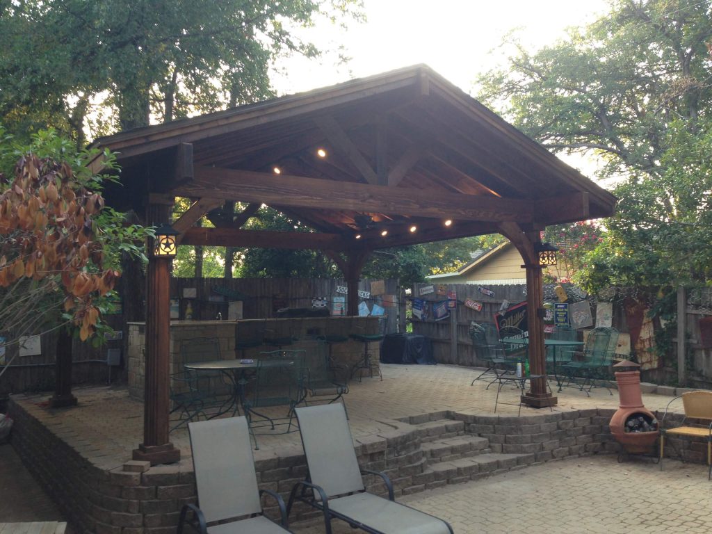 Example of a large mountain style backyard stone patio kitchen design in Dallas with a gazebo
