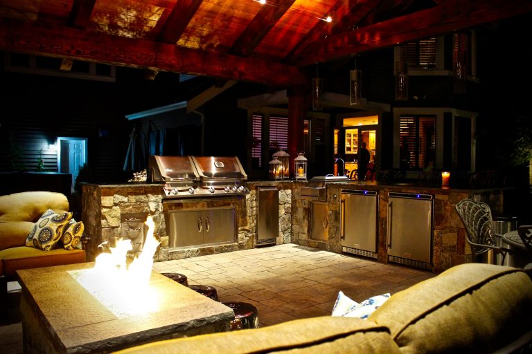 Example of a large mountain style backyard stone patio kitchen design in Seattle with a gazebo