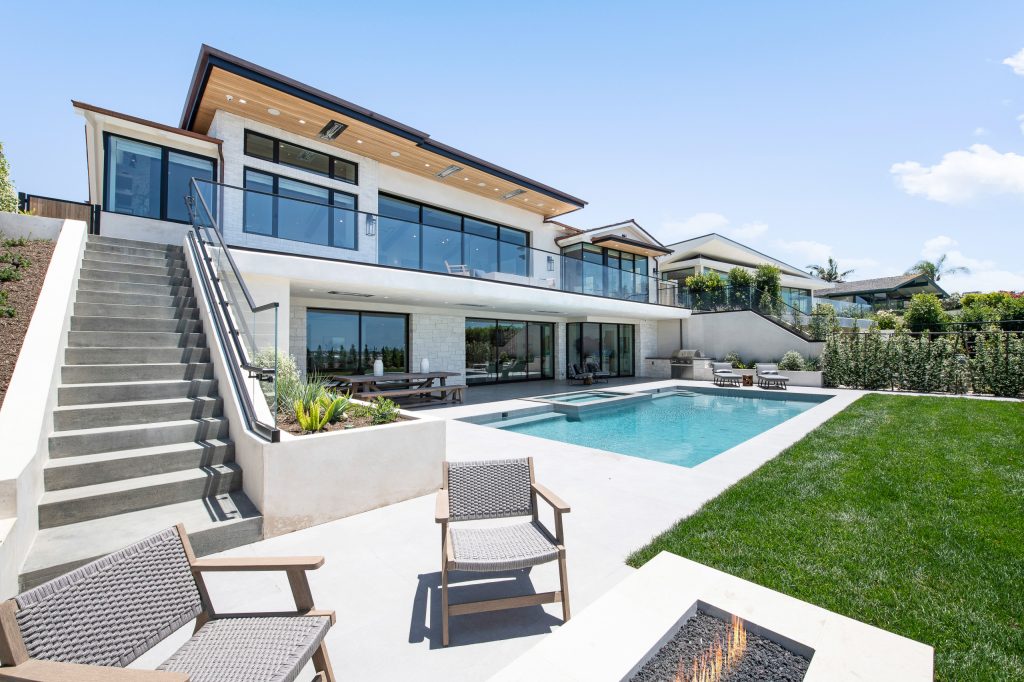 Example of a large transitional backyard concrete paver and rectangular lap hot tub design in Orange County