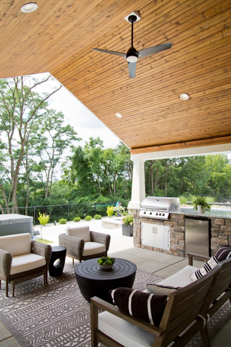 Example of a large transitional backyard concrete paver patio kitchen design in St Louis with a roof extension