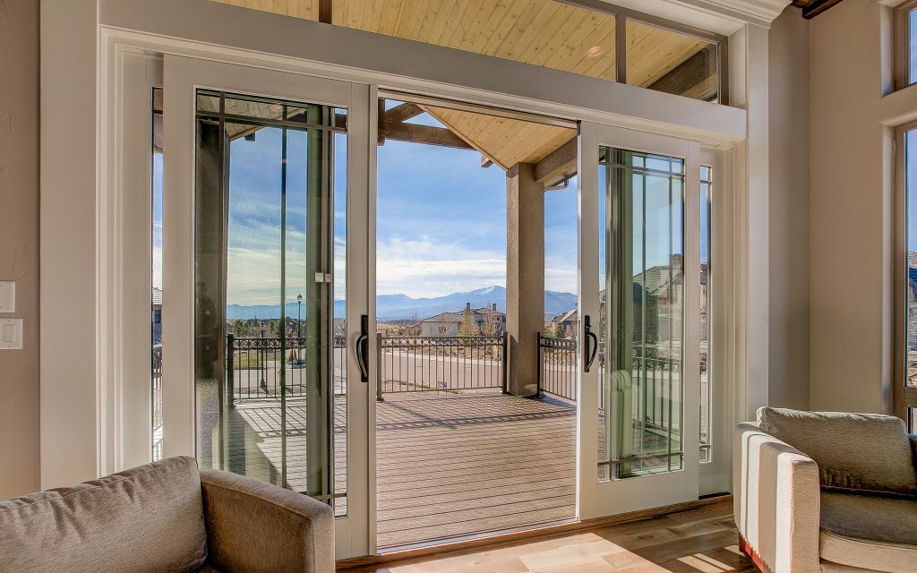 Example of a large transitional backyard deck design in Denver with a roof extension