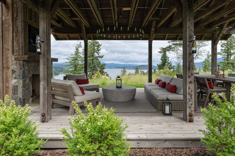 Example of a large transitional backyard deck design in Other with a fireplace and a roof extension