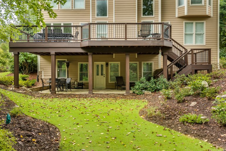 Example of a large transitional backyard patio kitchen design in Atlanta with a roof extension