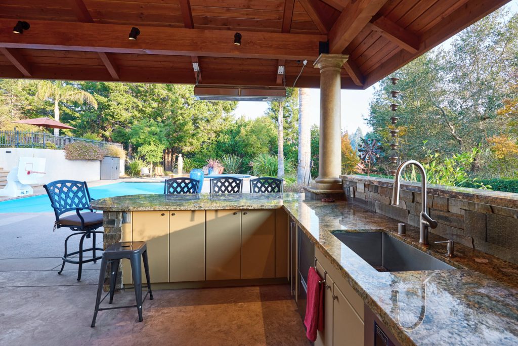 Example of a large transitional backyard stamped concrete patio kitchen design in Other with a gazebo
