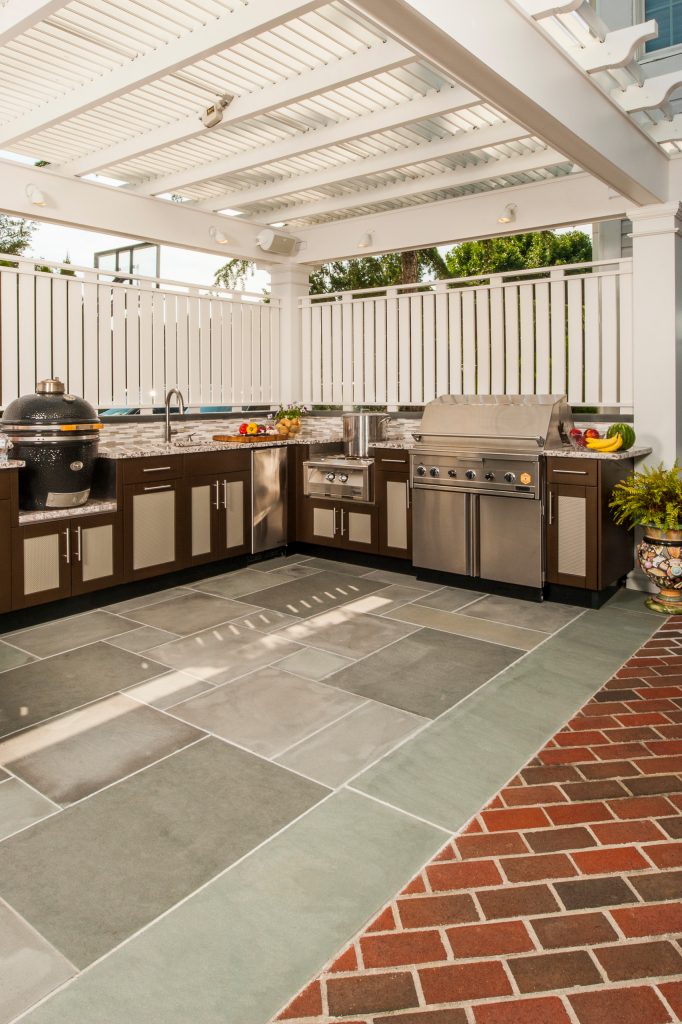Example of a large trendy backyard brick patio kitchen design in New York with an awning