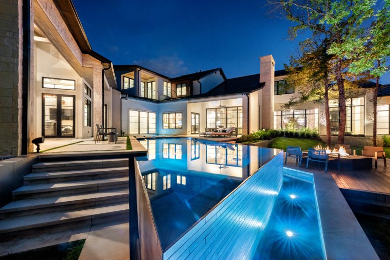 Example of a large trendy backyard concrete and custom-shaped infinity pool design in Dallas