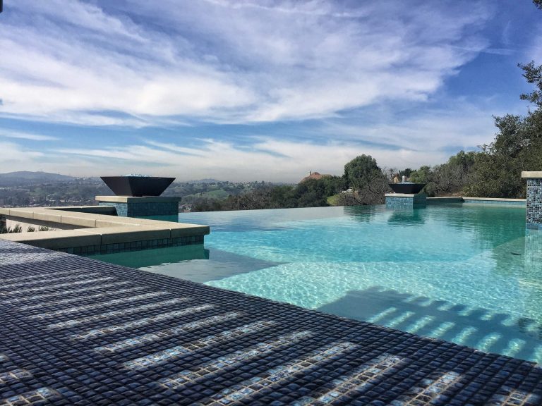 Example of a large trendy backyard concrete paver and rectangular infinity hot tub design in Los Angeles