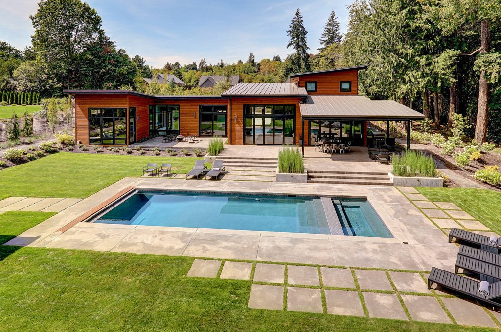 Example of a large trendy backyard concrete paver and rectangular lap pool house design in Portland