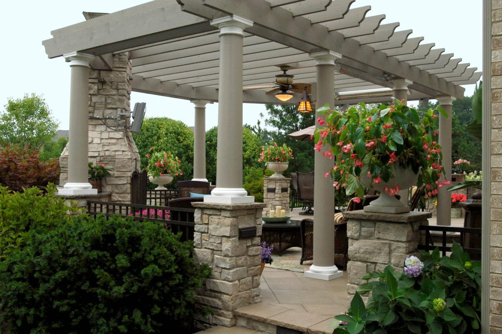 Example of a large trendy backyard concrete paver patio kitchen design in Chicago with a pergola