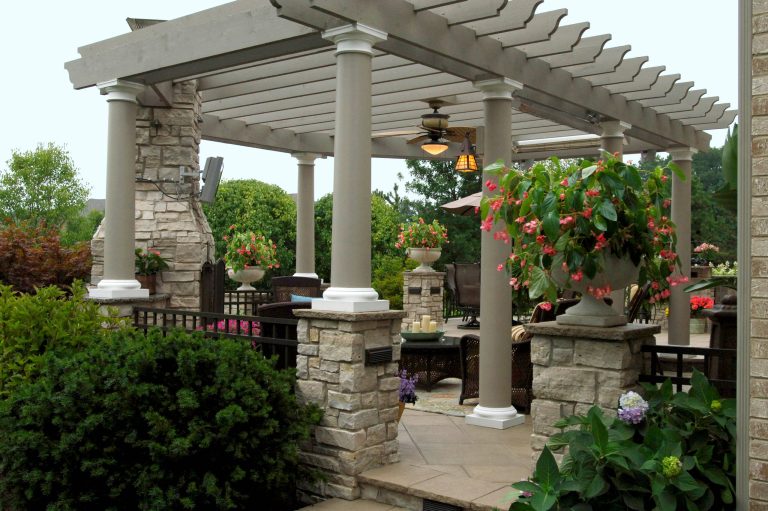Example of a large trendy backyard concrete paver patio kitchen design in Chicago with a pergola