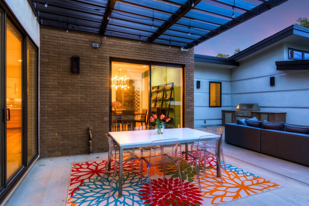 Example of a large trendy backyard concrete paver patio kitchen design in Denver with a pergola