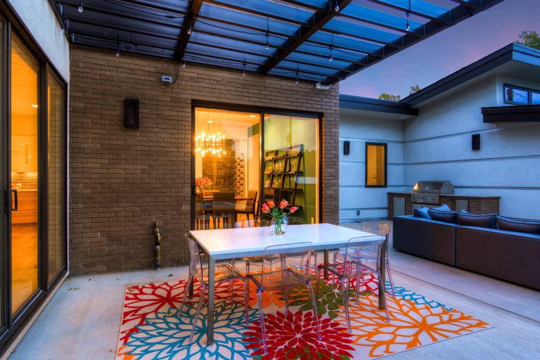 Example of a large trendy backyard concrete paver patio kitchen design in Denver with a pergola