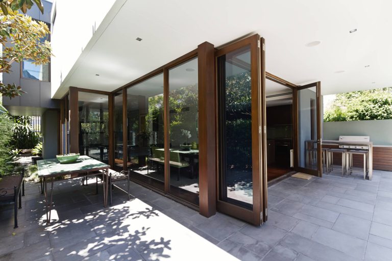 Example of a large trendy backyard concrete paver patio kitchen design in Orange County with a roof extension