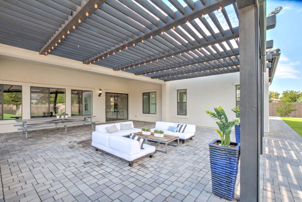 Example of a large trendy backyard concrete paver patio kitchen design in Phoenix with a roof extension