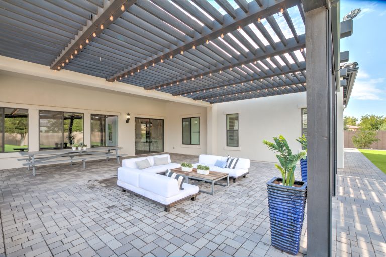Example of a large trendy backyard concrete paver patio kitchen design in Phoenix with a roof extension