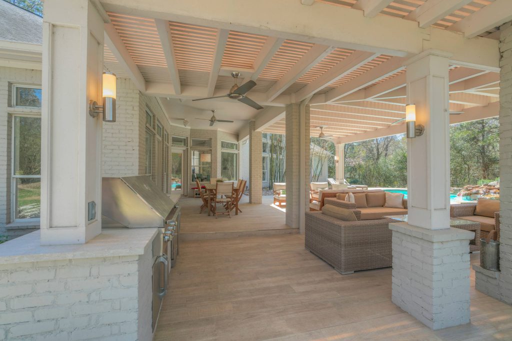 Example of a large trendy backyard patio kitchen design in Houston with decking and a roof extension