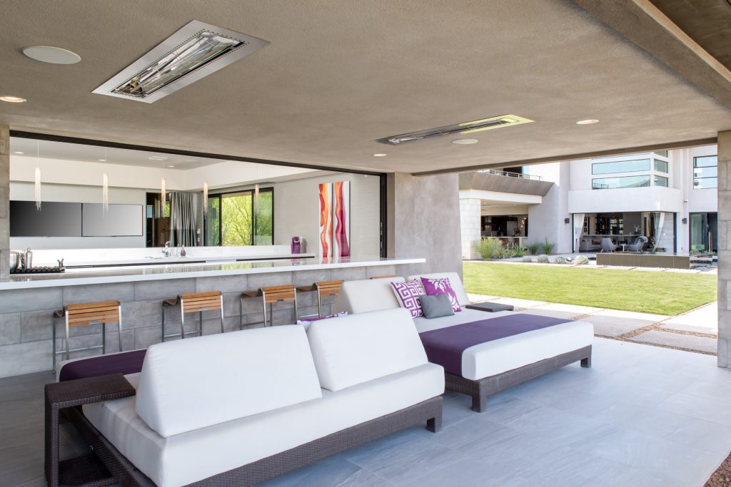Example of a large trendy backyard patio kitchen design in Las Vegas with a roof extension