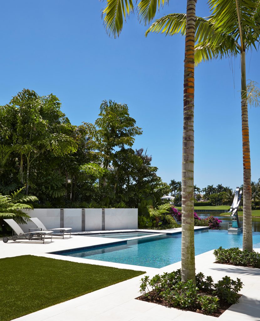 Example of a large trendy backyard rectangular infinity pool design in Miami