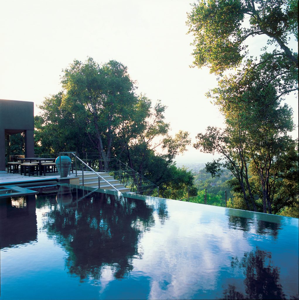 Example of a large trendy backyard stone and rectangular infinity pool fountain design in San Francisco