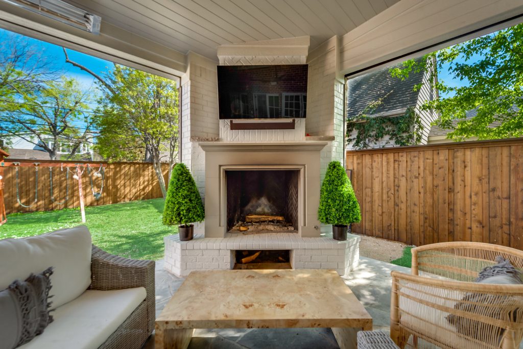 Example of a large trendy backyard stone patio kitchen design in Dallas with a roof extension