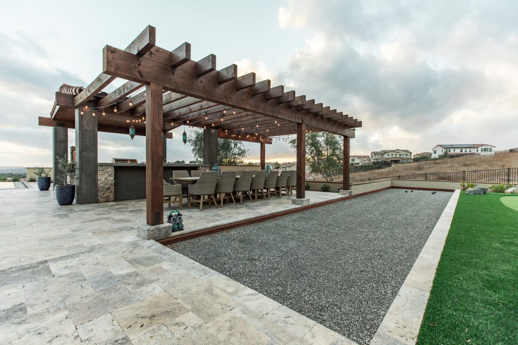 Example of a large trendy backyard stone patio kitchen design in San Diego with a pergola
