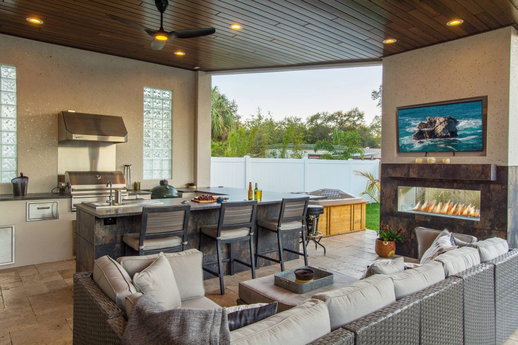 Example of a large trendy backyard stone patio kitchen design in Tampa with a roof extension