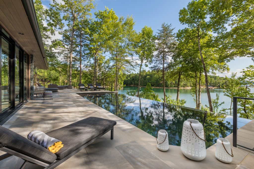 Example of a large trendy backyard tile and rectangular infinity pool design in Other