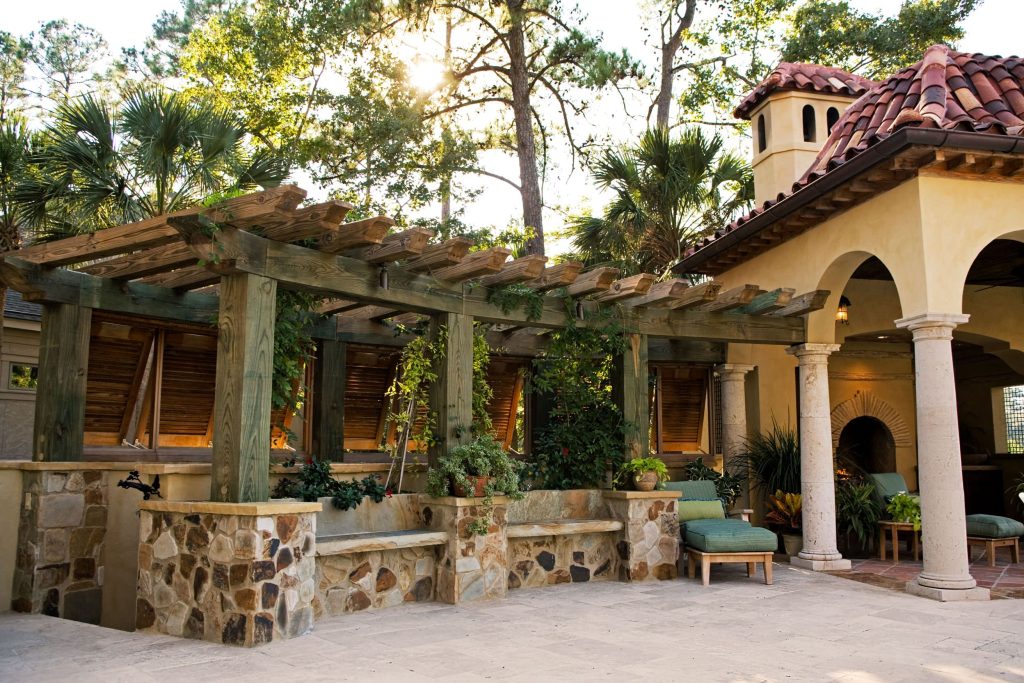 Example of a large tuscan backyard concrete paver patio kitchen design in Atlanta with a pergola