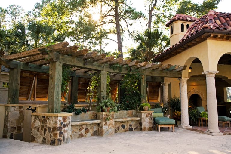Example of a large tuscan backyard concrete paver patio kitchen design in Atlanta with a pergola