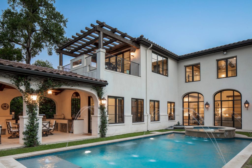 Example of a large tuscan backyard rectangular and tile pool fountain design in Austin