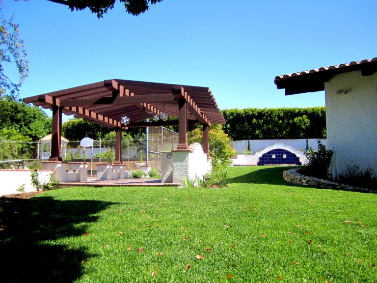 Example of a large tuscan backyard tile patio kitchen design in Los Angeles with a pergola