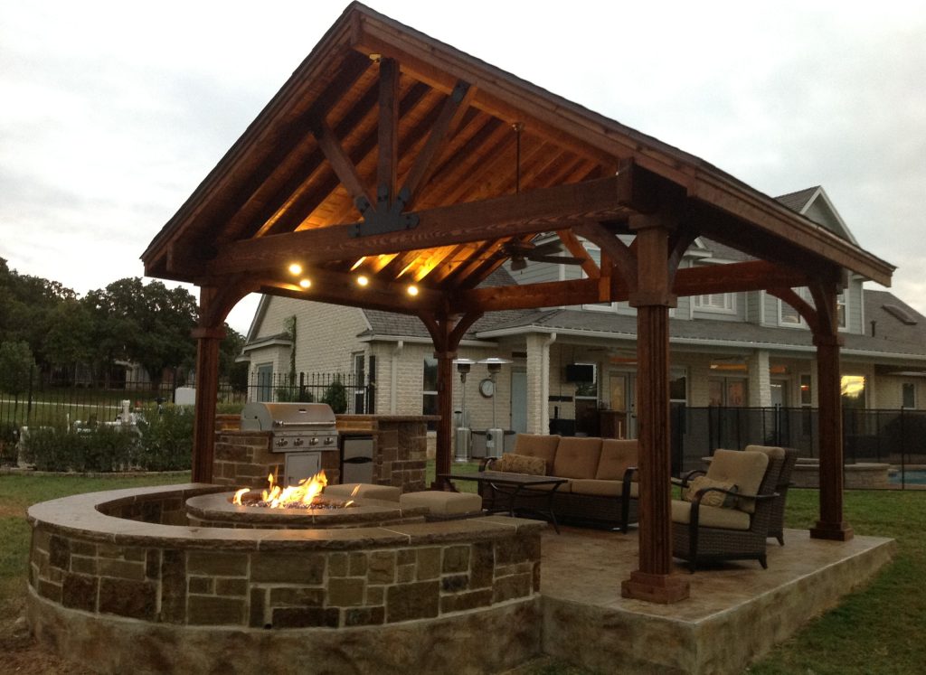 Example of a mid-sized arts and crafts backyard stamped concrete patio kitchen design in Dallas with a gazebo