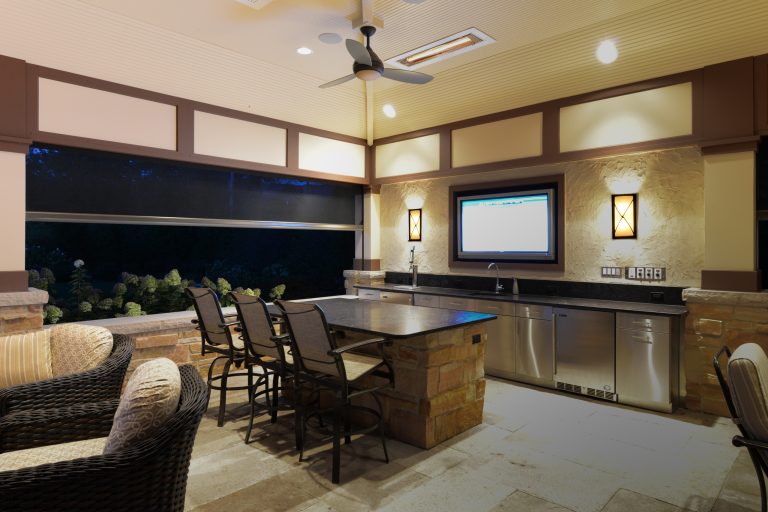 Example of a mid-sized arts and crafts backyard stone patio kitchen design in Chicago with a roof extension